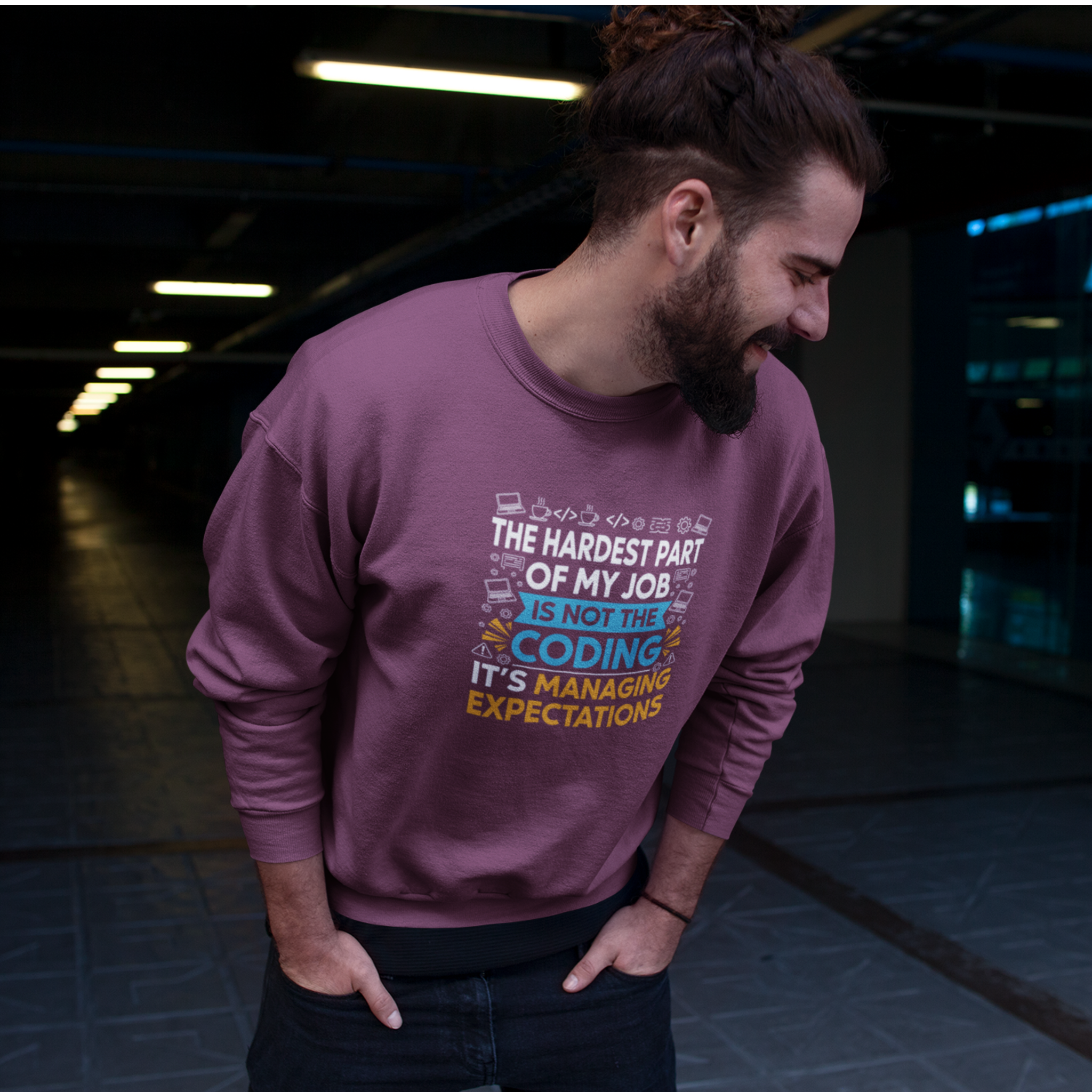 Man wearing a maroon sweatshirt with a humorous coding quote in an indoor setting.