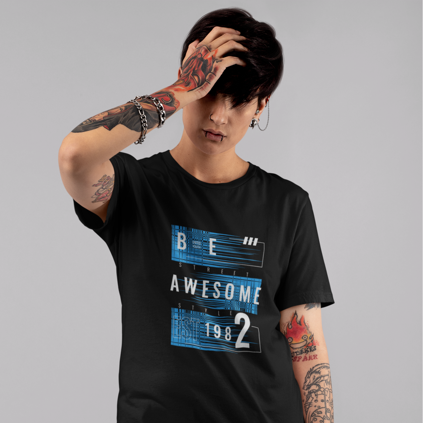 Person wearing a black t-shirt with 'Be Awesome 1982' design on a gray background